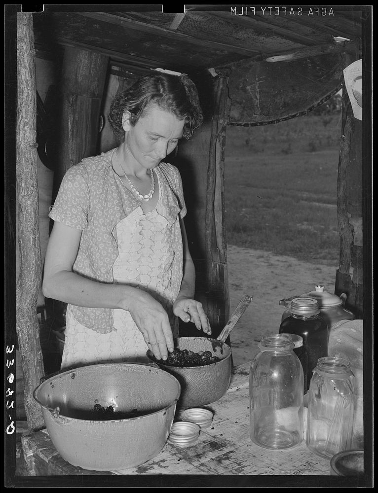 Wife of itinerant statue maker and agricultural day laborer canning berries. Poteau Creek near Spiro, Oklahoma, Sequoyah…