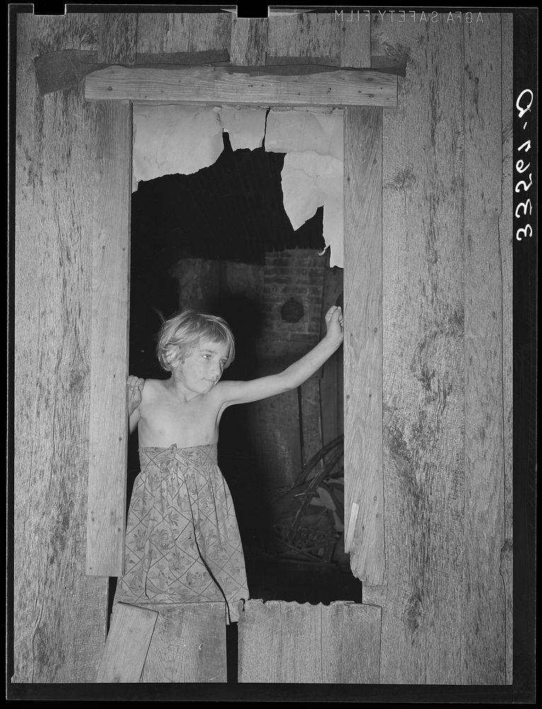 Daugher of day laborer standing in the window of her home in McIntosh County, Oklahoma by Russell Lee
