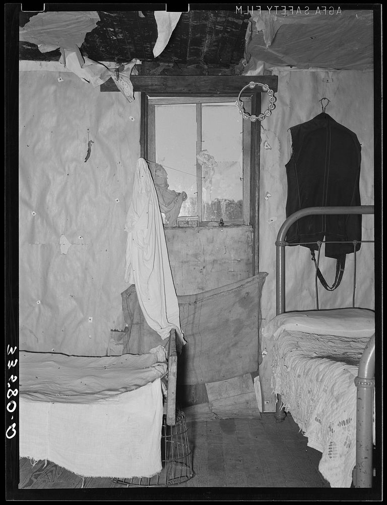 Bedroom and living room in home of white agricultural day laborer near Tullahassee, Oklahoma. Wagoner County by Russell Lee