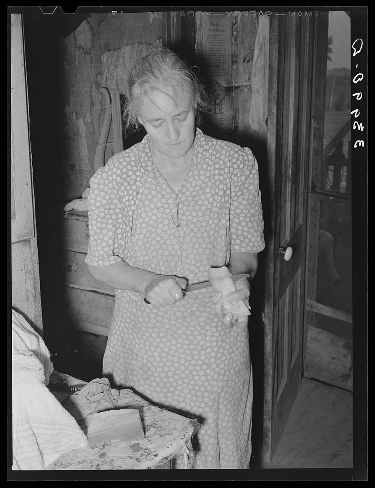 Wife of tenant farmer slicing fatback for noonday meal near Muskogee, Oklahoma. See general caption 20 by Russell Lee