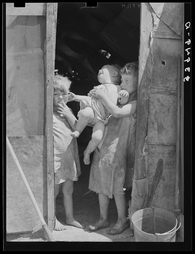 Children of Mays Avenue camp dressed in old sacks. Their father is a "trasher." Oklahoma City, Oklahoma by Russell Lee