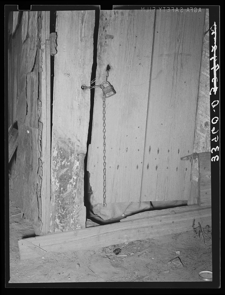 Locked door of shack. Mays Avenue camp, Oklahoma City, Oklahoma. The sense of possession is just as strong in this…