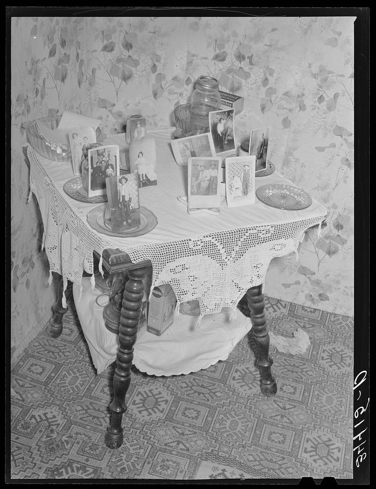 Photographs on table in Spanish-American farm home in Taos County, New Mexico by Russell Lee