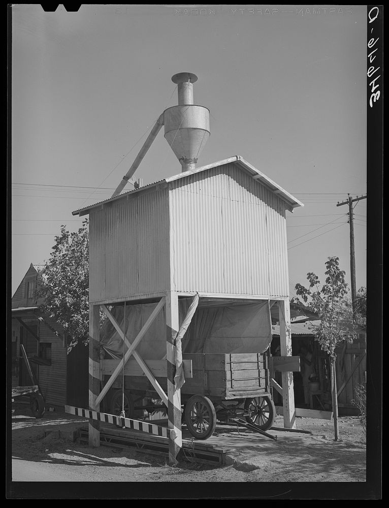 Wagon on scales at feed mill. Taylor, Texas. Ground feed is poured directly into the wagon from the hopper above by Russell…