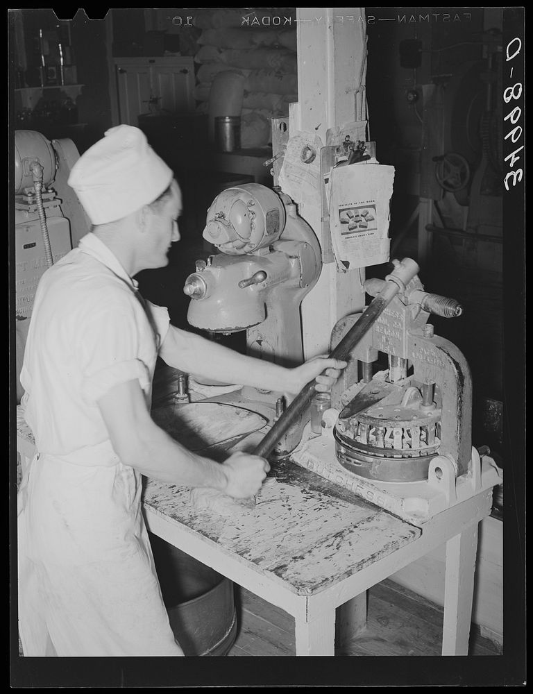 Stamping out squares of dough which will be made into rolls. Bakery, San Angelo, Texas by Russell Lee