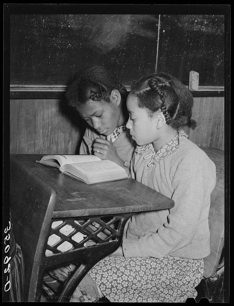 Two children sitting at desk in school. Child in foreground is the daughter of Pomp Hall, tenant farmer. Creek County…