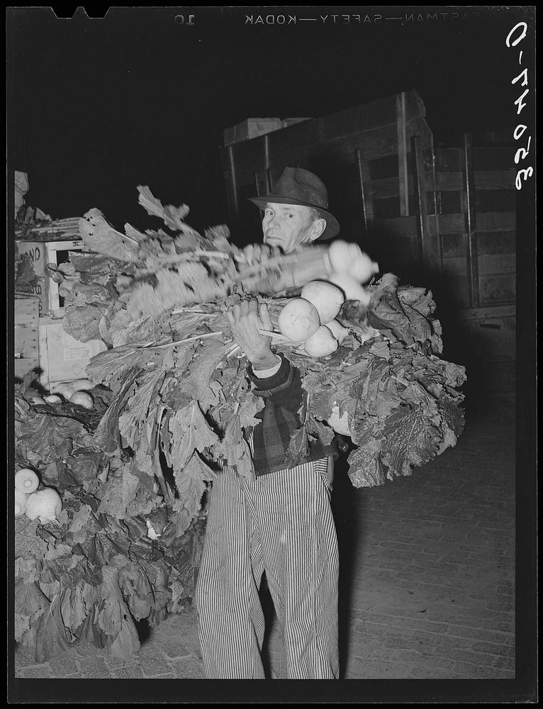 Truck farmer with an armload of turnips at early morning market. San Angelo, Texas by Russell Lee