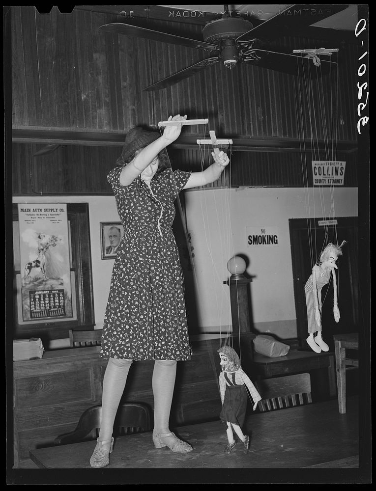 [Untitled photo, possibly related to: Member of the Red Dust Players, Oklahoma City theater group, operating puppets for the…