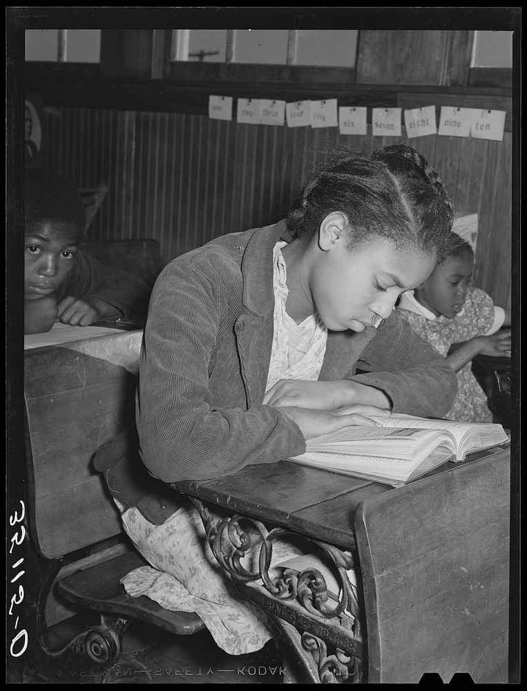 Daughter of Pomp Hall,  tenant farmer, studying at her desk in rural school. Creek County, Oklahoma. See general caption…