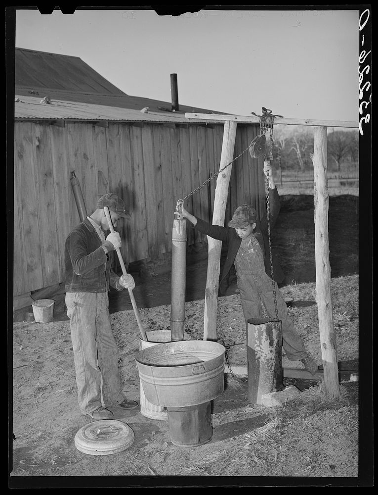 Sons of Pomp Hall,  tenant farmer, drawing water and mixing bran mash to feed the hogs. Creek County, Oklahoma. See general…