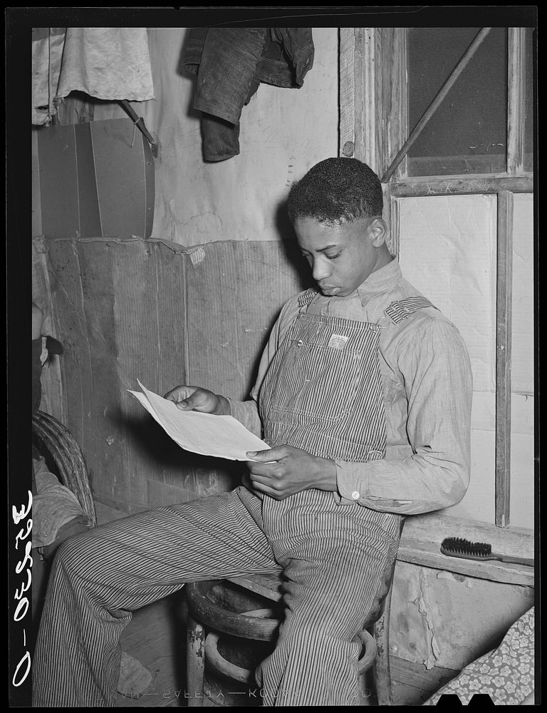 Son of Pomp Hall,  tenant farmer, studying price list of agricultural equipment. Creek County, Oklahoma. See general caption…