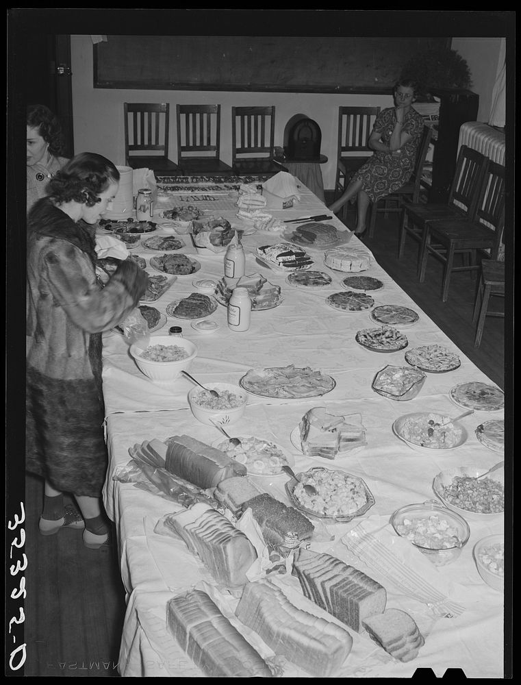 Wife of Jaycee member bringing food to the buffet supper at the high school. Eufaula, Oklahoma. See general caption number…