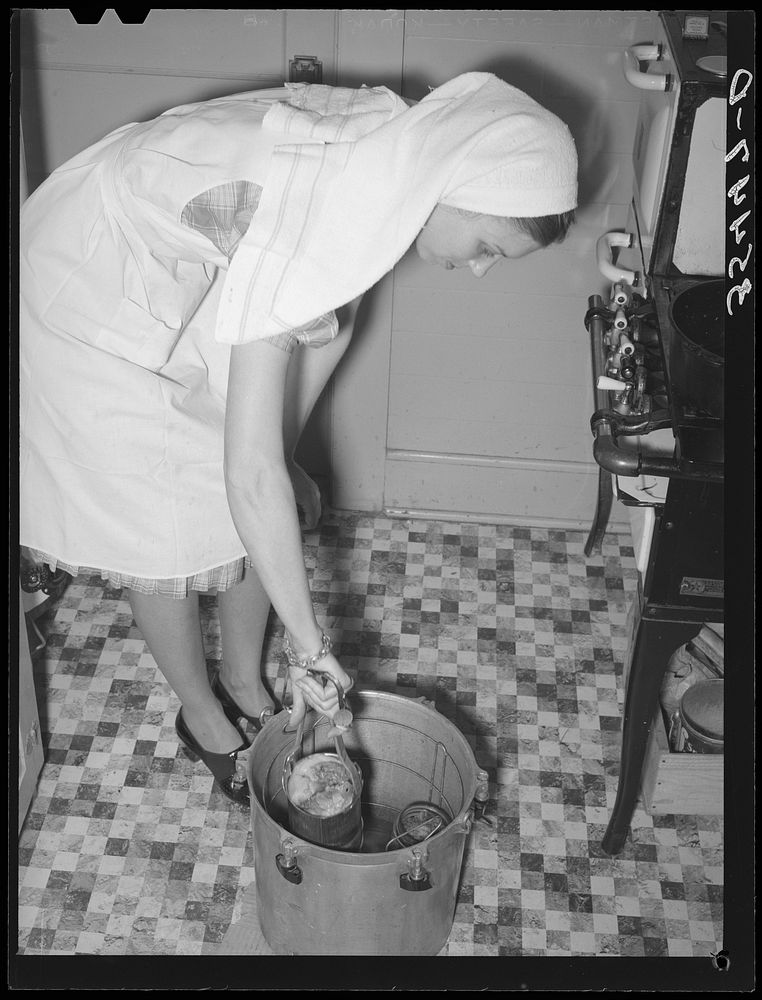 FSA (Farm Security Administration) supervisor giving a demonstration of pressure canning before a group of FSA officials at…