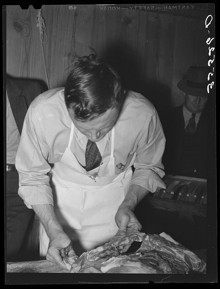 [Untitled photo, possibly related to: FSA (Farm Security Administration) supervisor making sausage during a meat cutting…