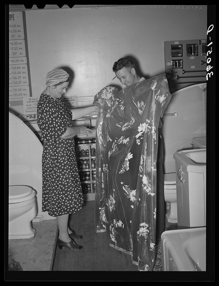 Member of the United Producers and Consumers Cooperative looking at a shower curtain displayed by salesman in the household…