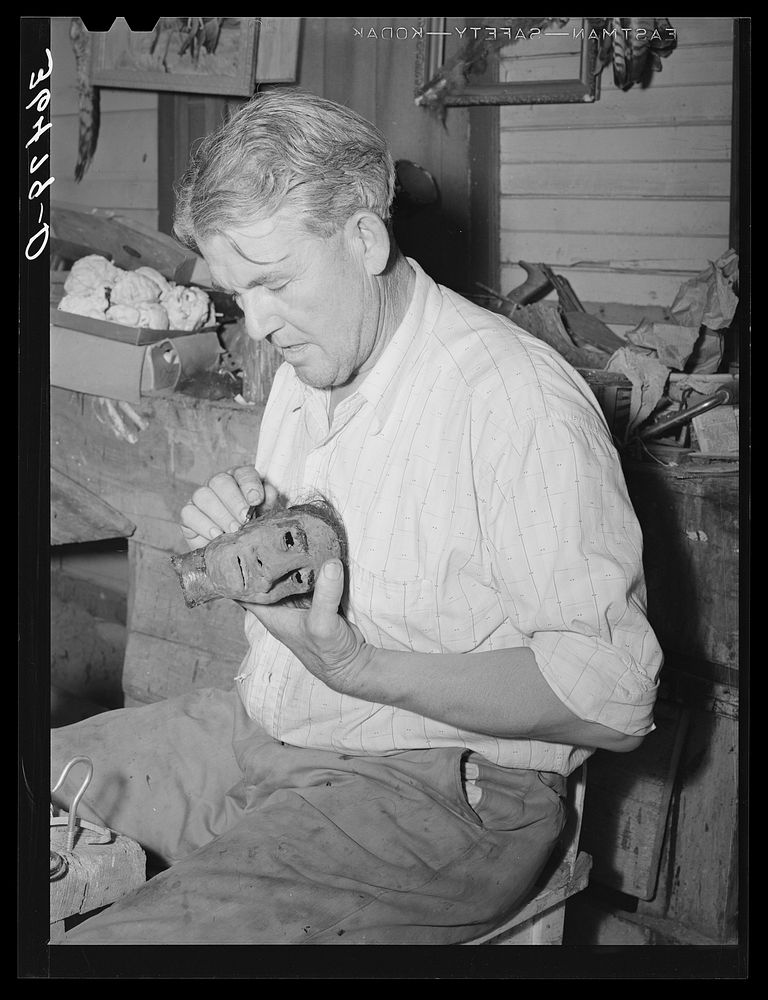 Homer Tate working on a papier mache head. Safford, Arizona by Russell Lee
