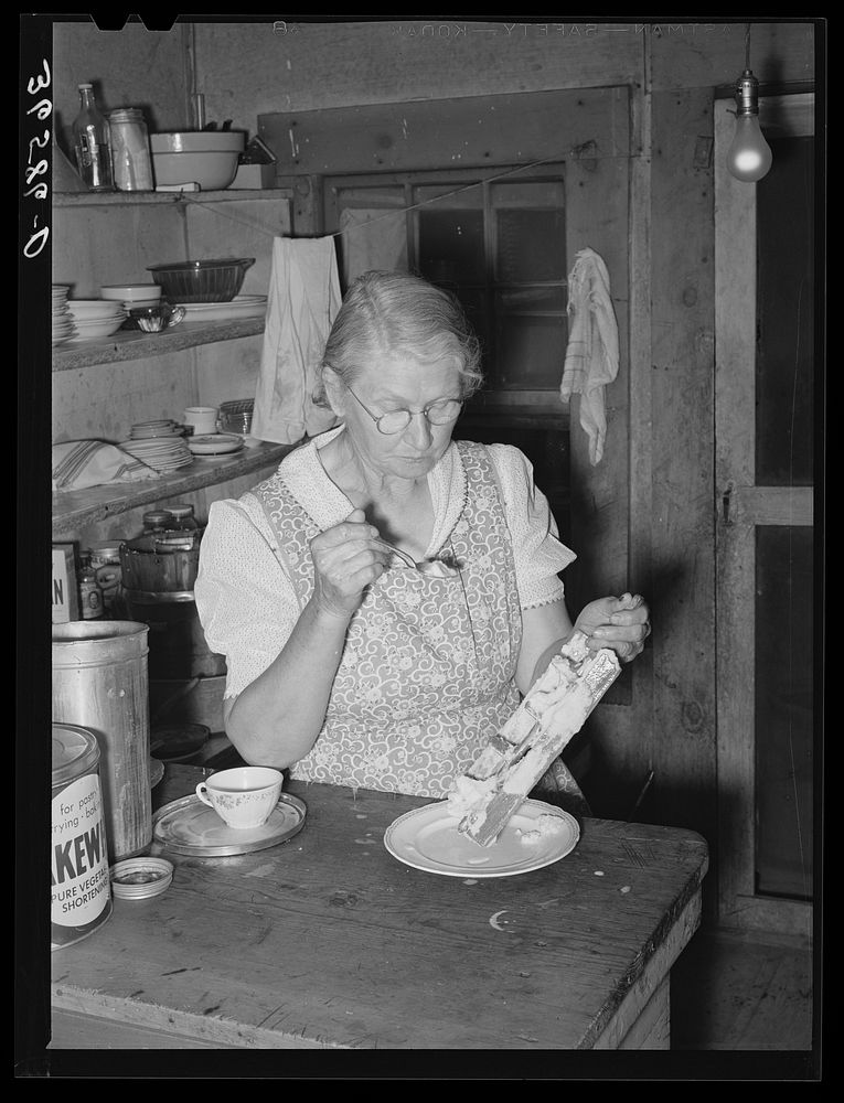 Mrs. Holley Sr. eating ice cream from the dasher. Pie Town, New Mexico by Russell Lee