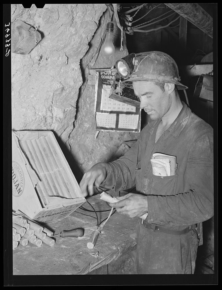Miner inserting fuse into stick of dynamite. Mogollon, New Mexico by Russell Lee