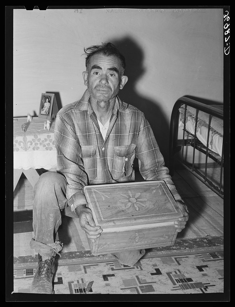 Spanish-American man with chest which he carved. He hopes to sell his work to tourists. Chamisal, New Mexico by Russell Lee