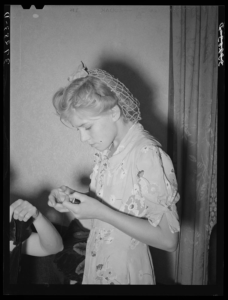 Mormon girl threading a needle. Snowville, Utah by Russell Lee