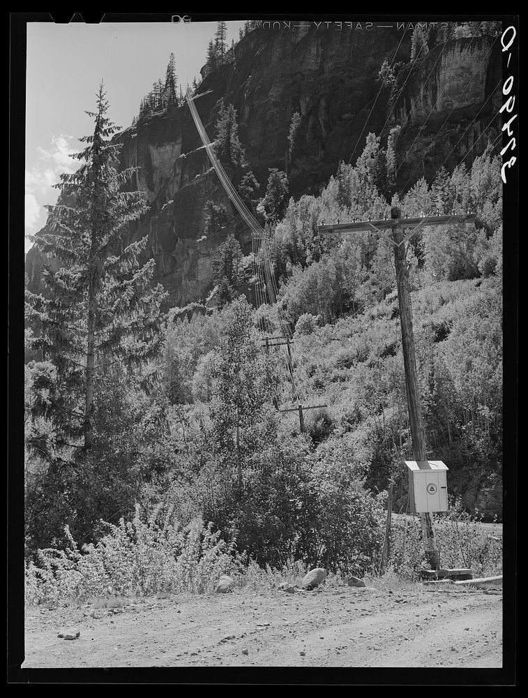 Telephone wires stretched up a mountainside on road. Camp Bird Mine, Ouray County, Colorado by Russell Lee