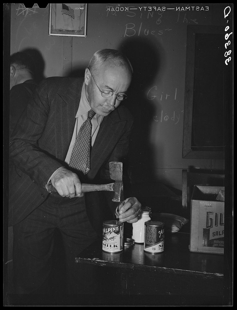 Farmer opens can of milk for coffee at farmers meeting. Gold Hill, California, Placer County, California by Russell Lee