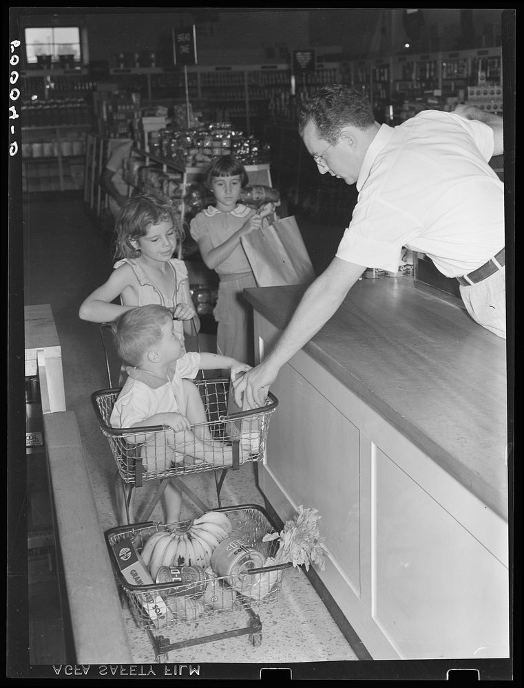 Children of Greenbelt, Maryland family buying groceries in cooperative store. Sourced from the Library of Congress.