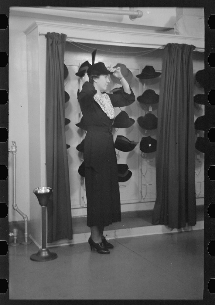 Model trying on hat for a buyer, New York City showroom, Jersey Homesteads cooperative by Russell Lee