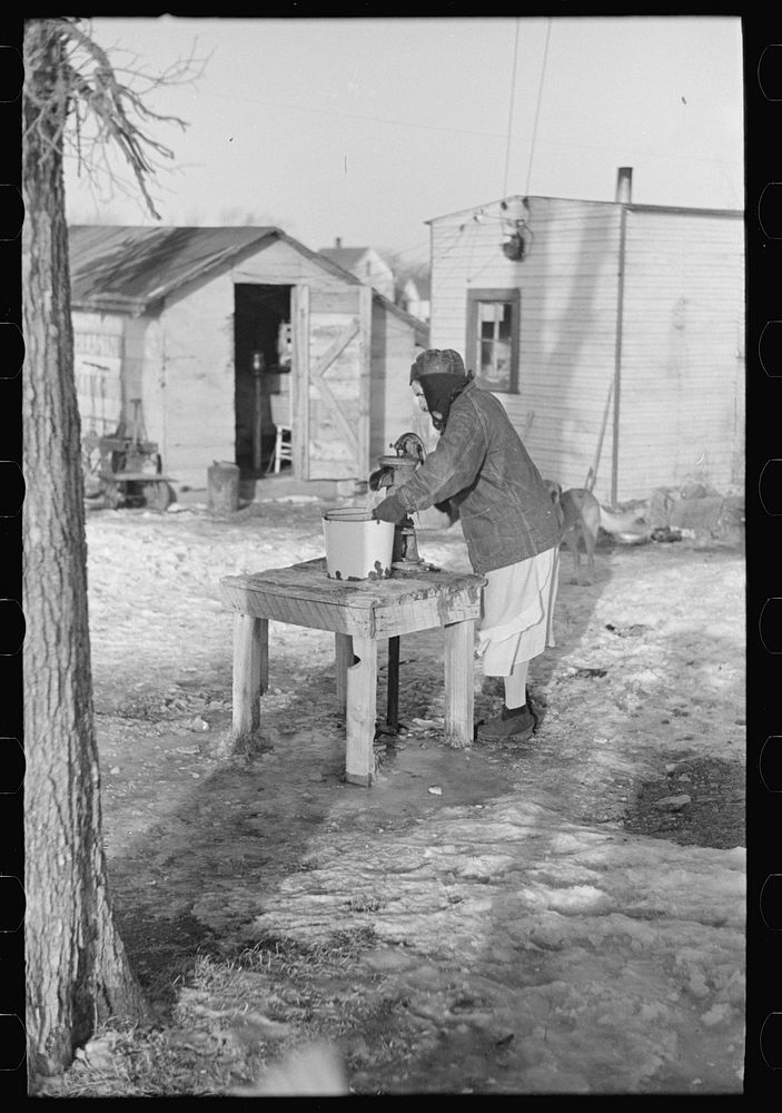 Woman pumping water for laundry, "Shantytown," Spencer, Iowa by Russell Lee