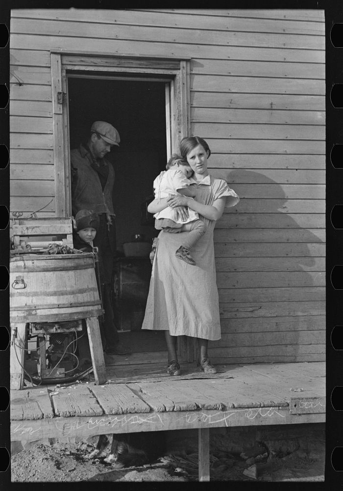 Mrs. Glen Cook and baby with Mr. Cook in background, Little Sioux township, Woodbury County, Iowa by Russell Lee