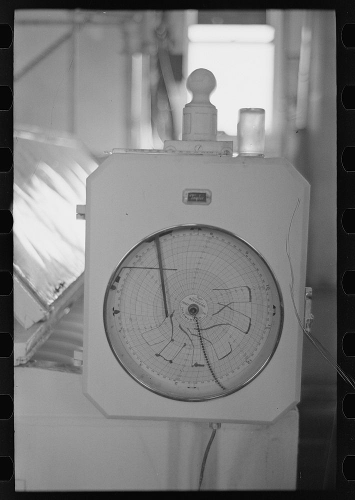 Automatic recording thermometer in cooperative creamery at Ruthven, Iowa. The latest scientific instruments are used here by…