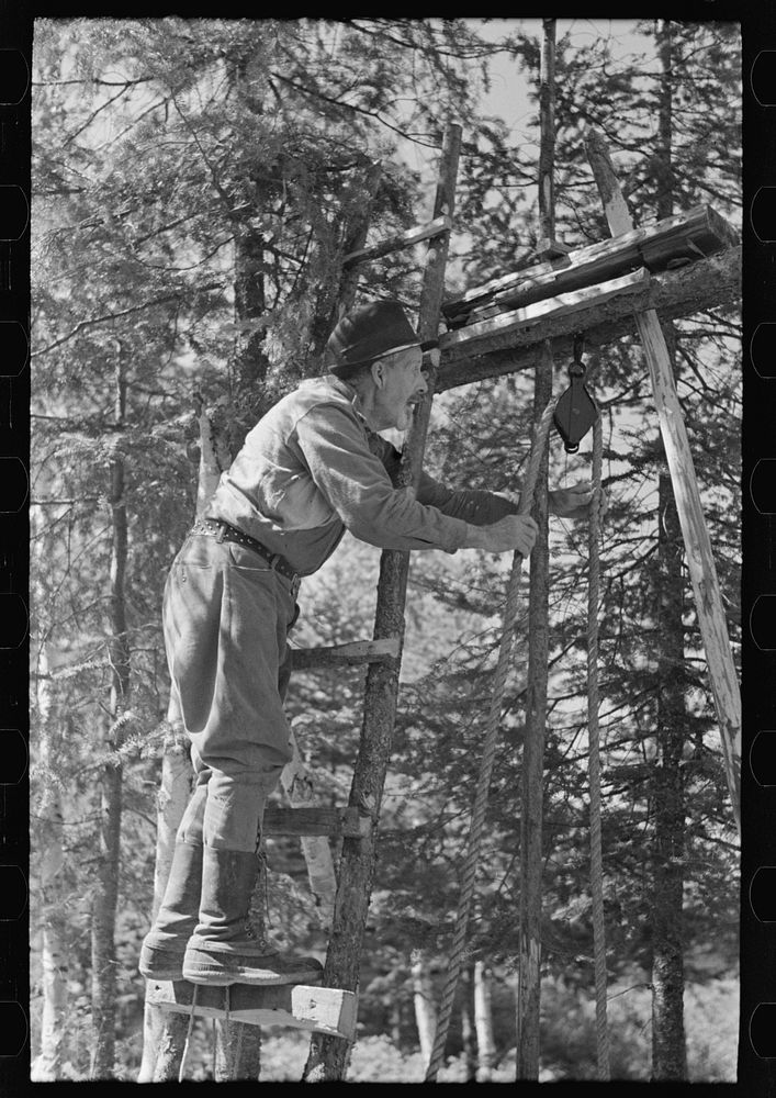 William Besson working on his drilling rig on location, near Winton, Minnesota by Russell Lee