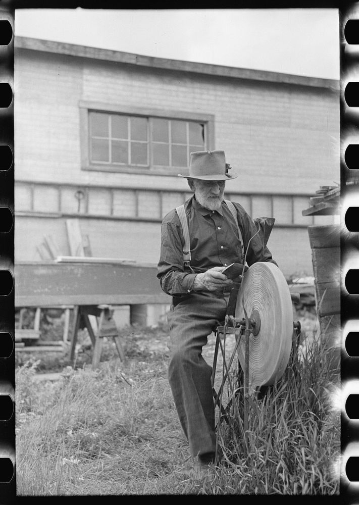 Old resident of Winton, Minnesota, sharpening an axe by Russell Lee