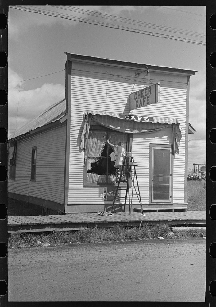 Girl washing windows of cafe, Cook, Minnesota by Russell Lee