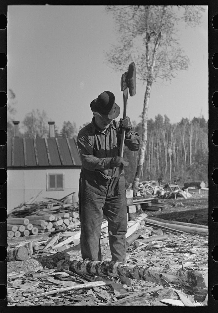 Lumberjack using a broadaxe at camp near Effie, Minnesota by Russell Lee