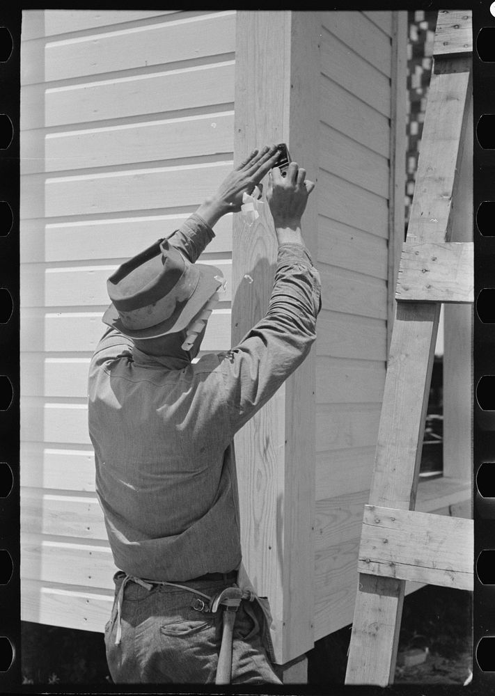 [Untitled photo, possibly related to: Southeast Missouri Farms Project. Finishing off corner board of one of the new houses]…