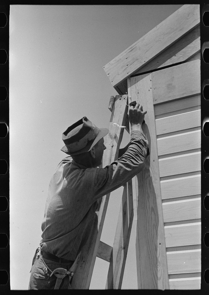 [Untitled photo, possibly related to: Southeast Missouri Farms Project. Finishing off corner board of one of the new houses]…