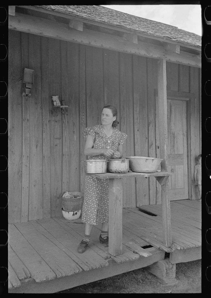 [Untitled photo, possibly related to: Wife of FSA (Farm Security Administration) client shelling peas on porch of old shack…