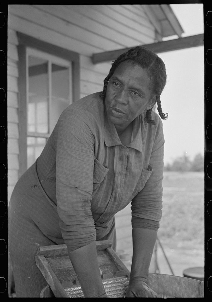 Wife of FSA (Farm Security Administration) client, former sharecropper, washing on back porch of old home, Southeast…
