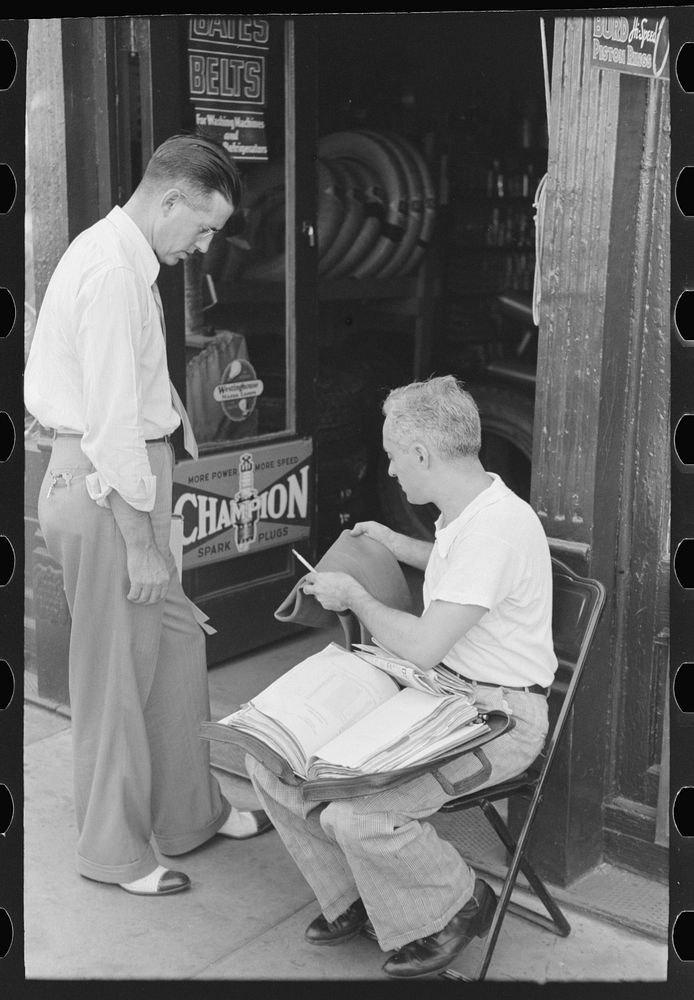 Tire salesman showing wares to storekeeper, Caruthersville, Missouri by Russell Lee