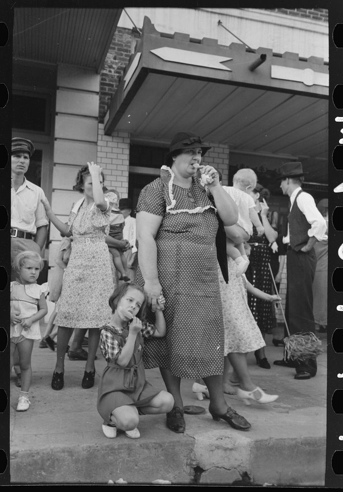 People standing on sidewalk watching parade, National Rice Festival, Crowley, Louisiana by Russell Lee