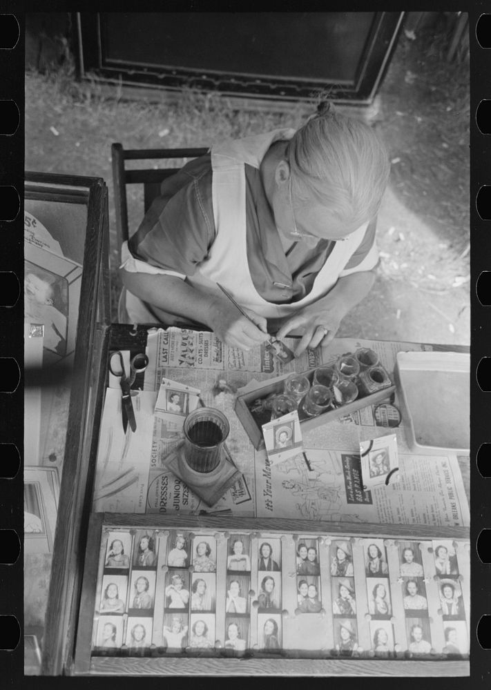 Wife of traveling photographer tinting small portraits, National Rice Festival, Crowley, Louisiana by Russell Lee
