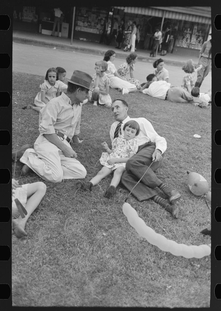 [Untitled photo, possibly related to: People resting on grass plot in middle of street, National Rice Festival, Crowley…