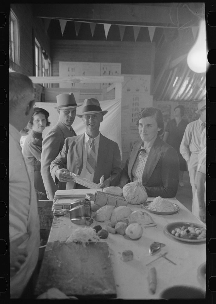 [Untitled photo, possibly related to: Women watching accomplishments of vegetable shredder at display, state fair…