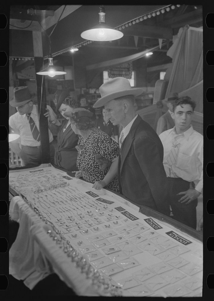 [Untitled photo, possibly related to: Man and woman looking at display of cheap jewelry, state fair, Donaldsonville…