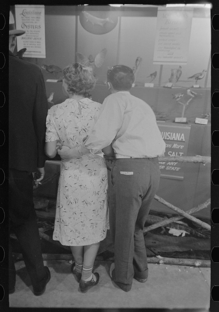 Loving couple look at exhibit, state fair, Donaldsonville, Louisiana by Russell Lee