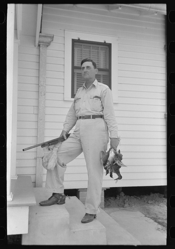 Joseph La Blanc, wealthy Cajun farmer, standing on steps of home with birds from a morning shooting, Crowley, Louisiana by…