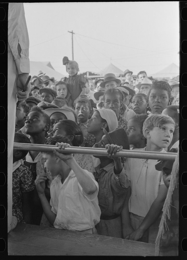 Children listening to barker at sideshow, state fair, Donaldsonville, Louisiana by Russell Lee