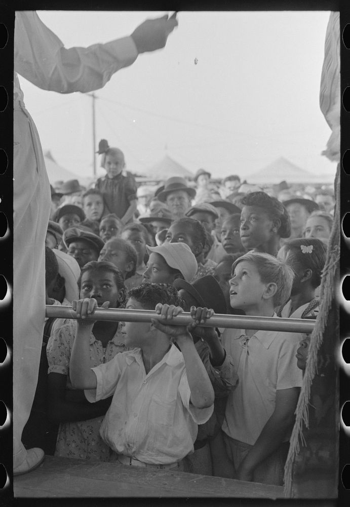 [Untitled photo, possibly related to: Children listening to barker at sideshow, state fair, Donaldsonville, Louisiana] by…