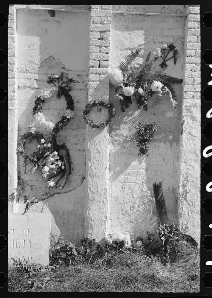 Decorations on side of family burial vault in cemetery at New Roads, Louisiana on All Saints' Day by Russell Lee